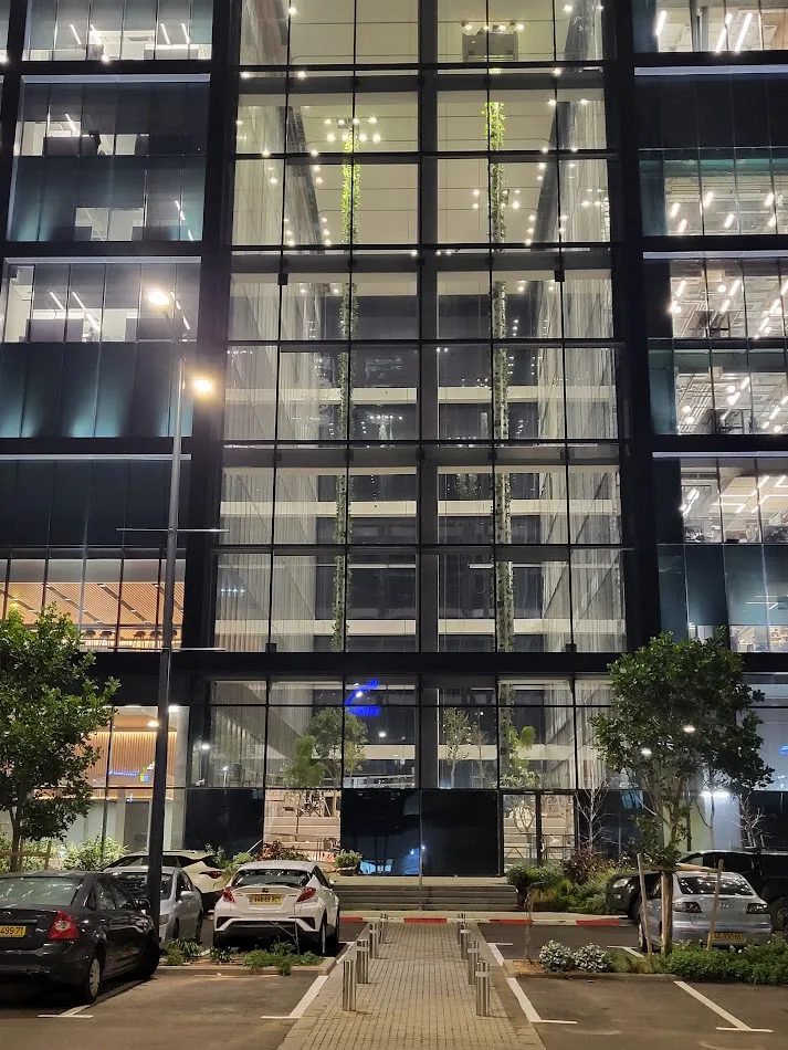 The full-height atrium glazing with hanging gardens lit from within
