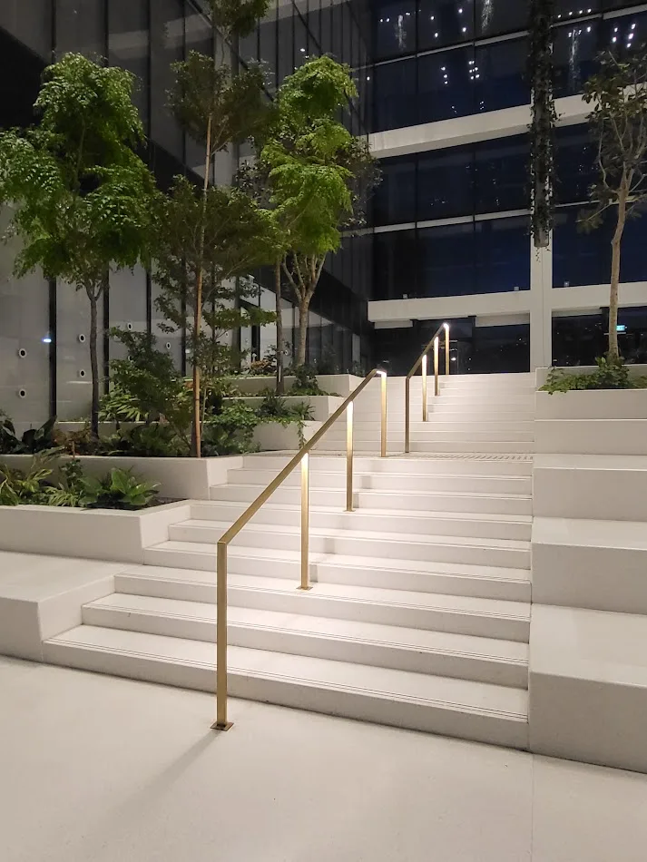 Lit brass handrails on the main-lobby terraced steps