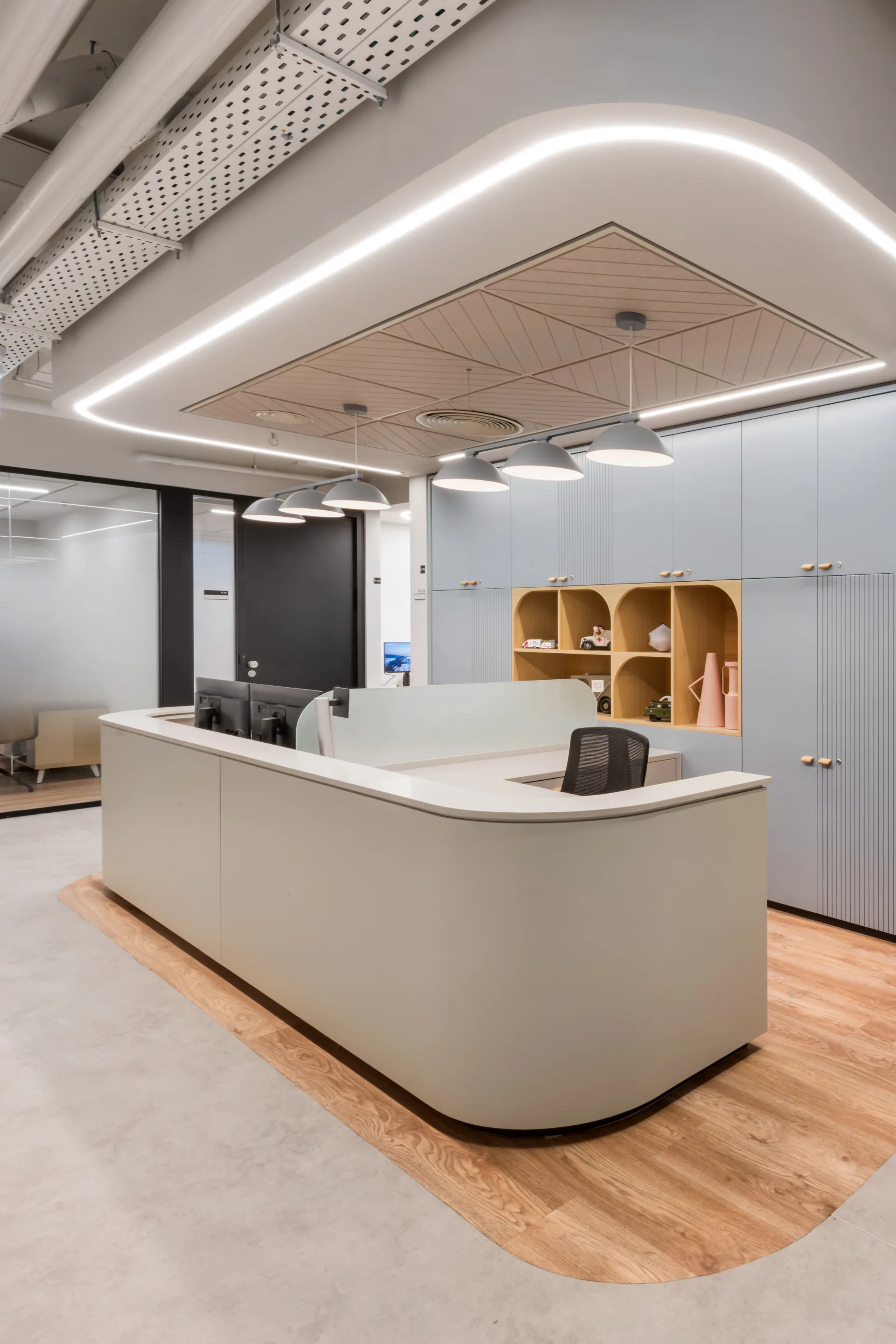 Curved reception desk beneath a perimeter light line