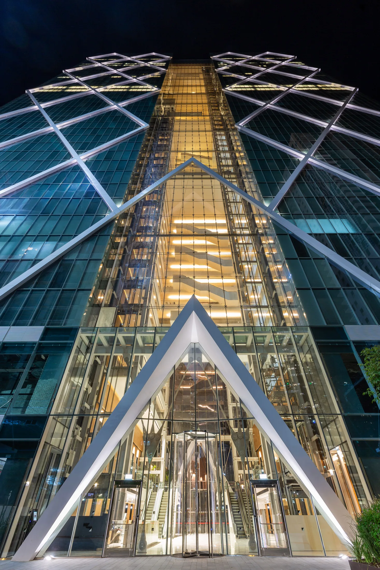 An upward view of the glowing diamond facade at dusk