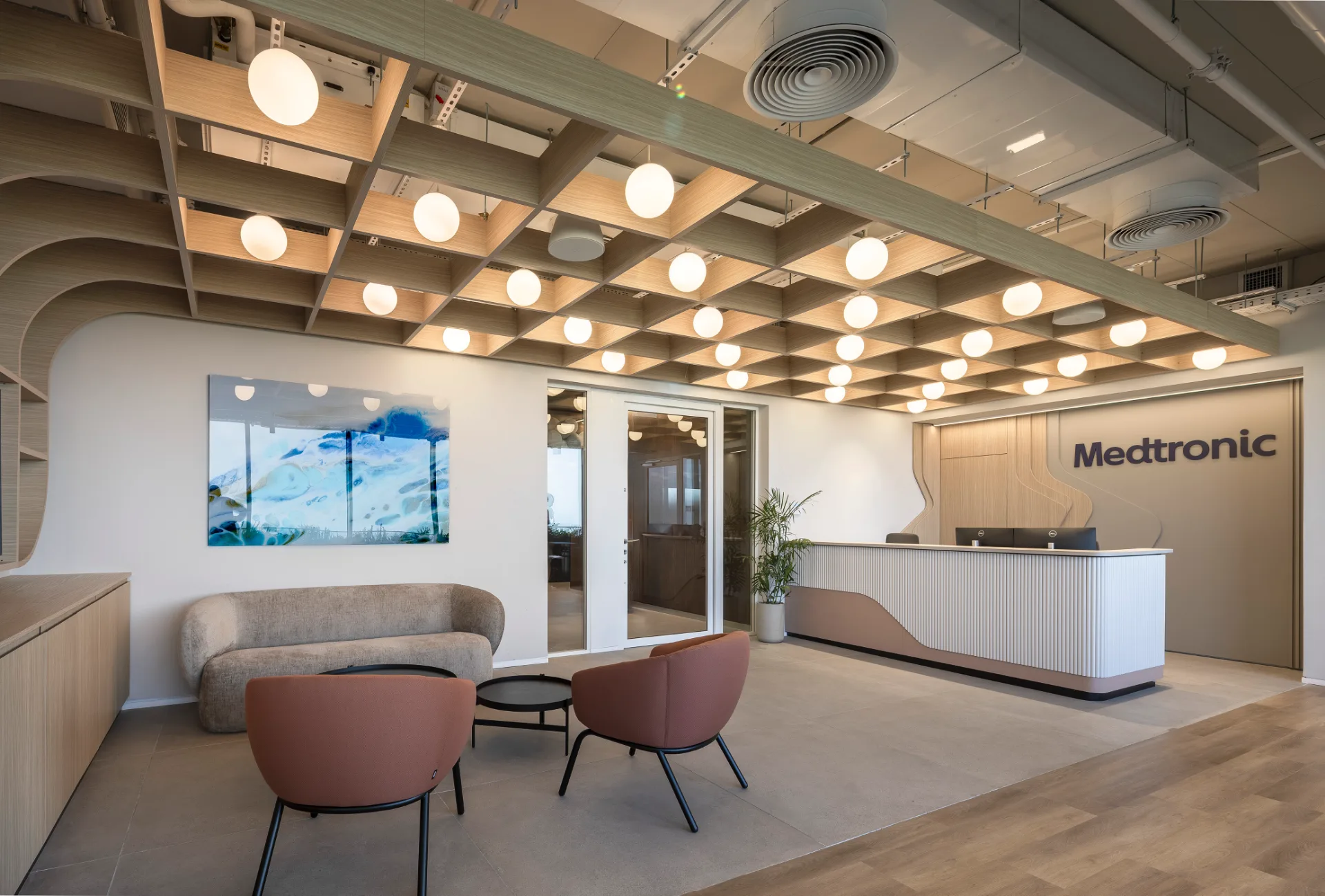 Open-plan work area beside glass-walled offices