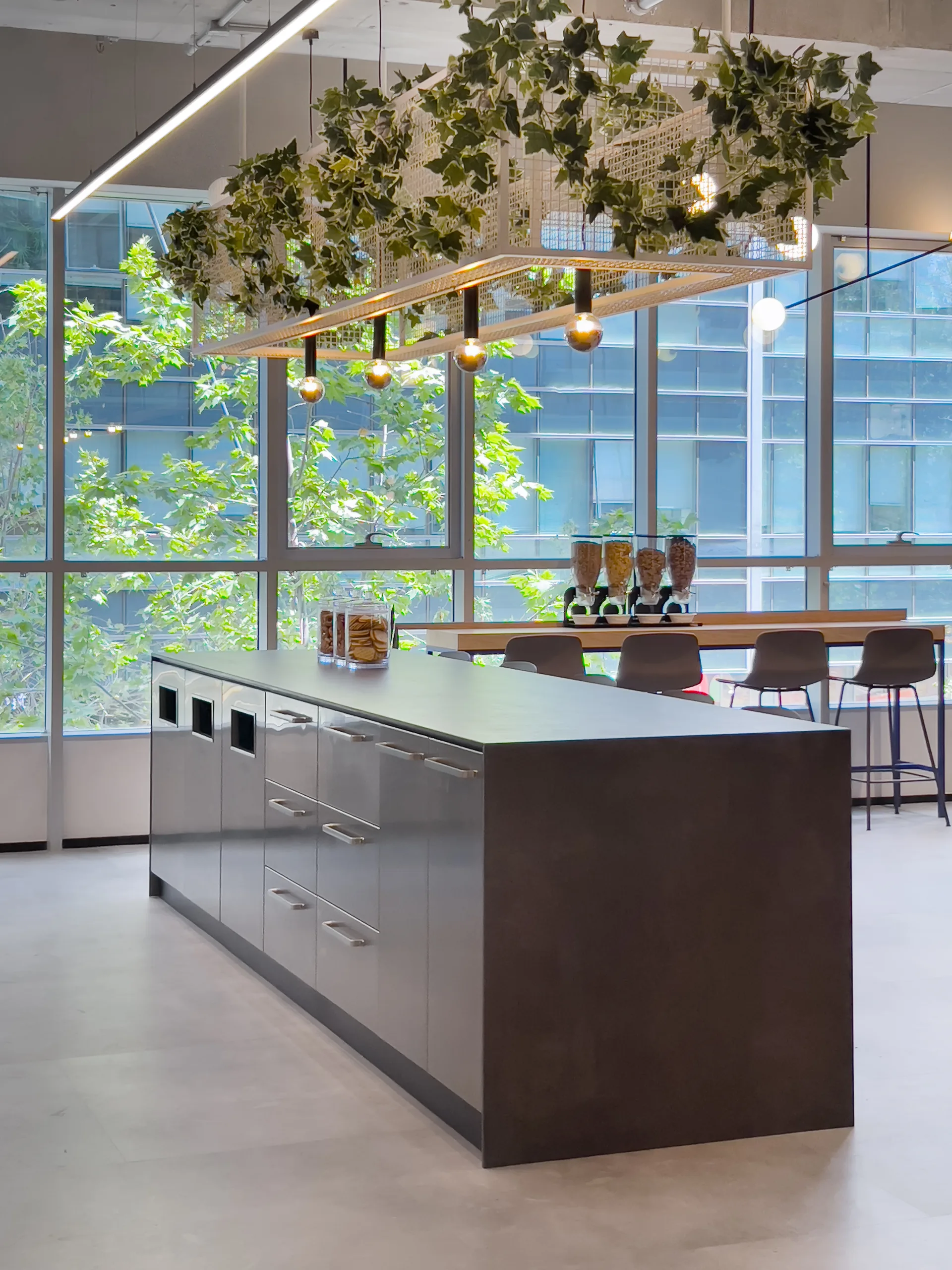 Kitchen island beneath an illuminated greenery frame