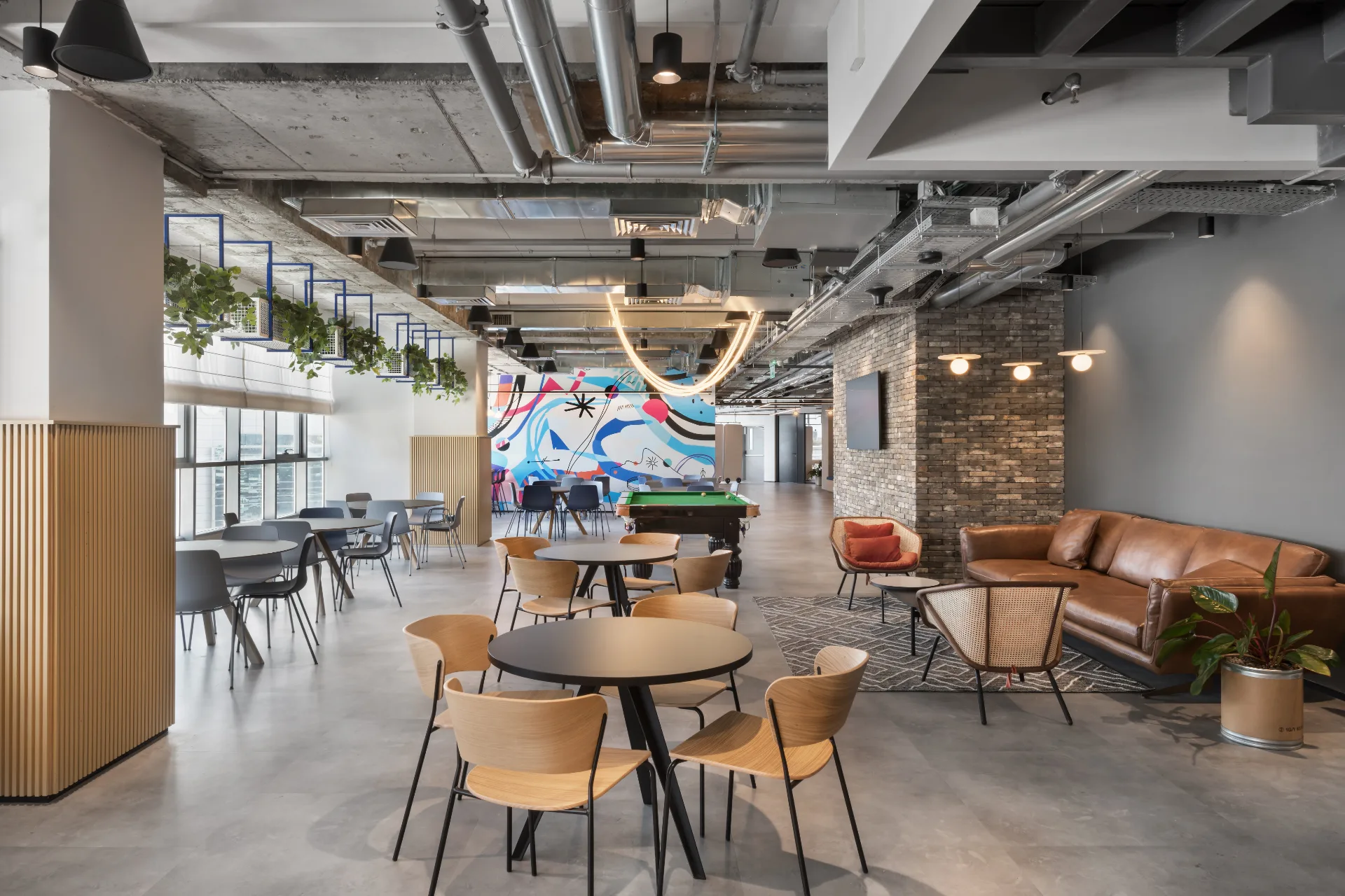 Breakout lounge with a brick wall, leather sofa, and a light loop
