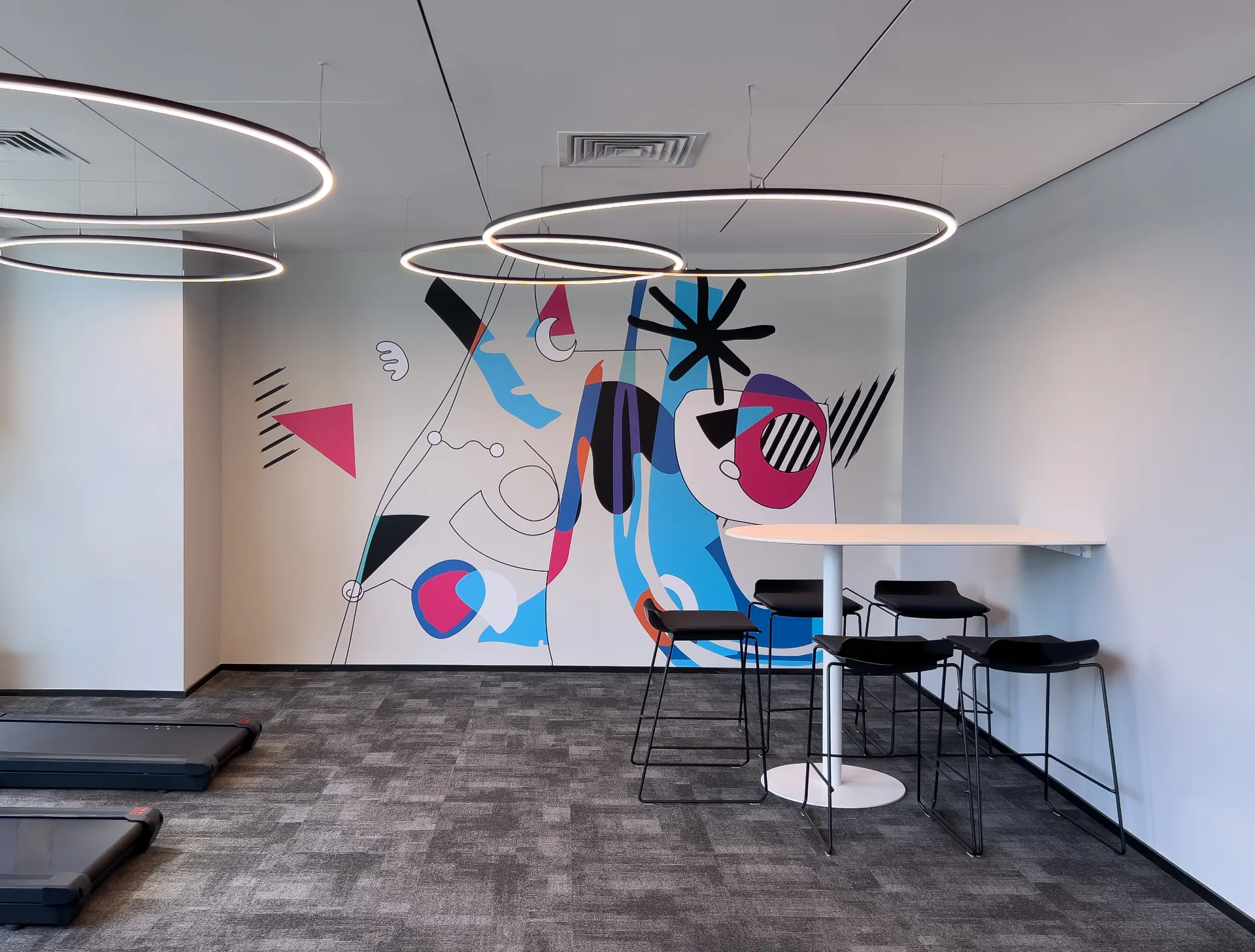Gym with light rings and a mural
