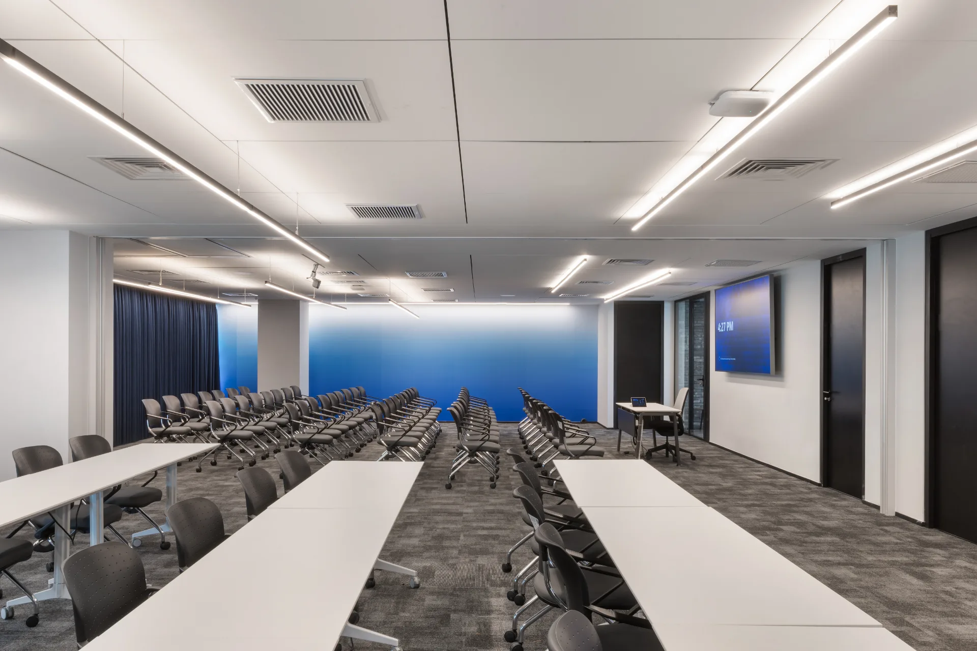 Training hall with a blue wall and suspended light lines