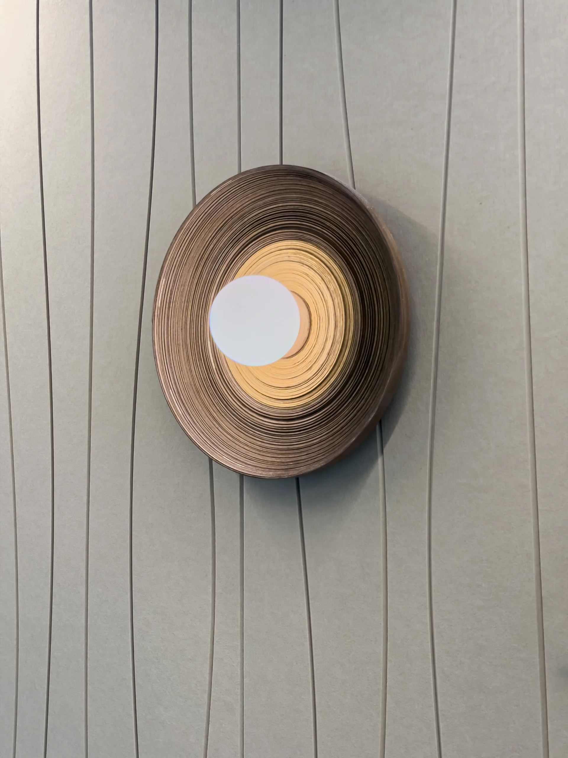 Globe wall sconce on a layered timber disc