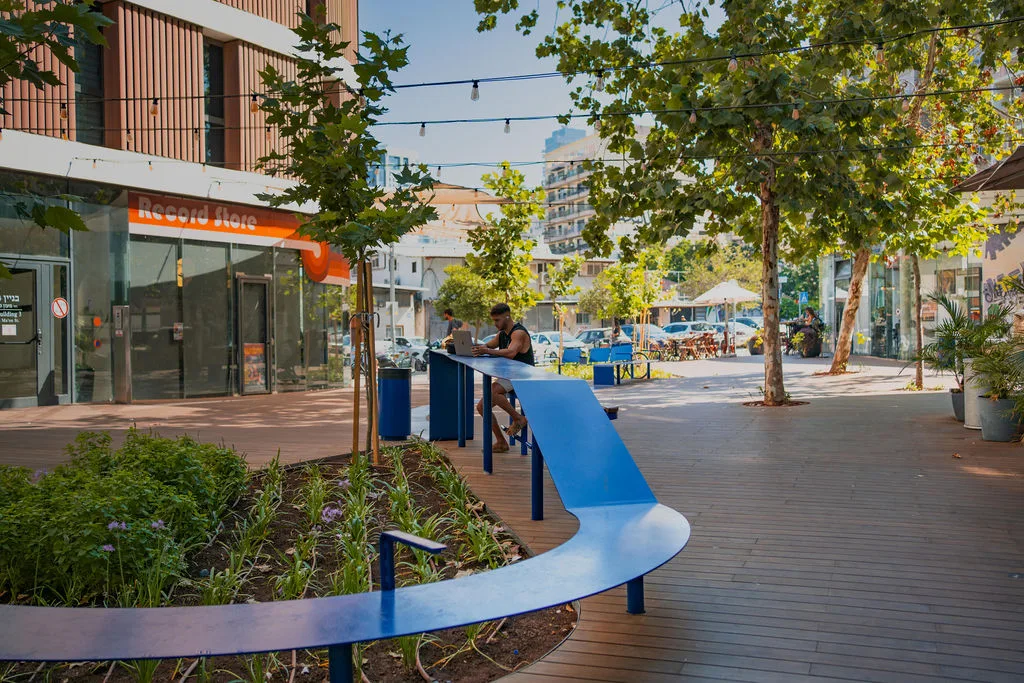 Curved blue bench and festoon lighting along the public corridor
