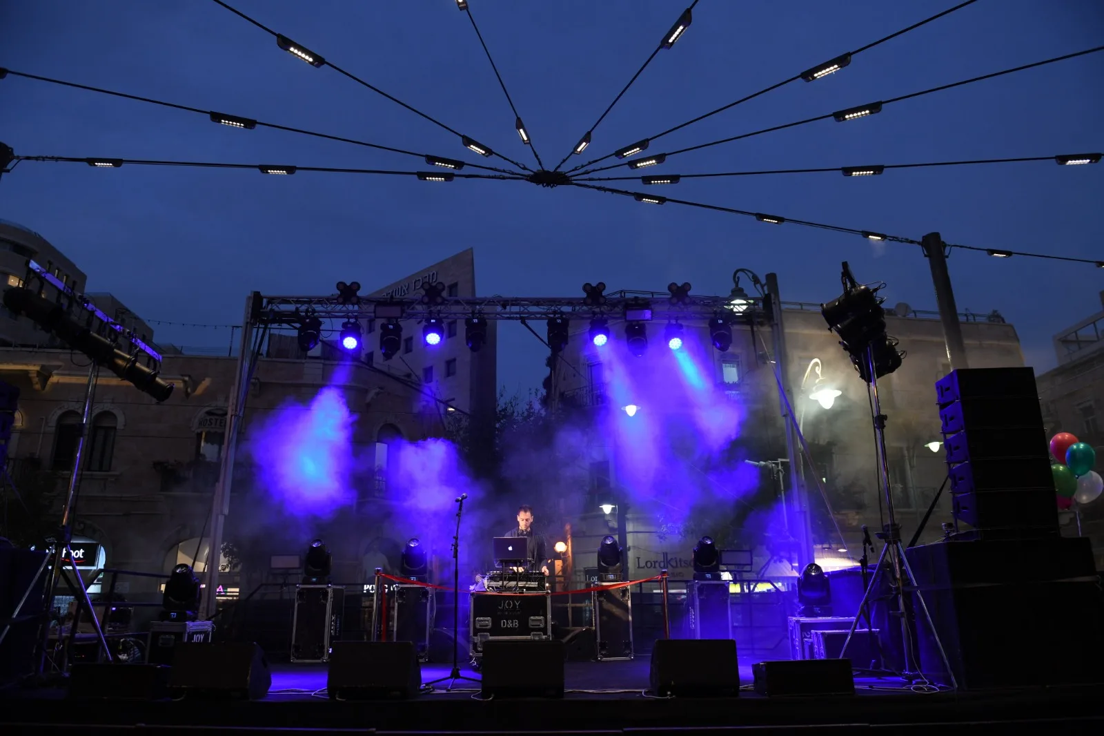 An evening event beneath the radial lighting array spanning the square